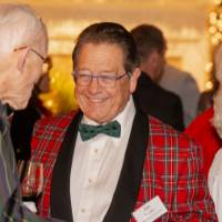 Jim Brooks in festive blazer greeting other reception guest